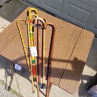 Five wooden canes laid on table