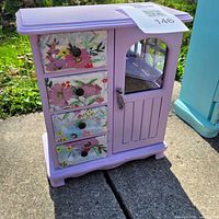 Front view of purple jewellery box with floral decoupage drawers and glass door