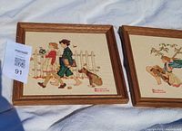 Both framed needlepoints side by side