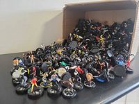 Loose pile of HeroClix figures spilling from box