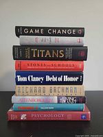 Stack of nine assorted books showing spines for titles and authors