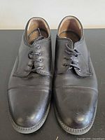 Front view of both shoes showing cap-toe design and lacing