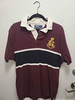 Front view maroon short-sleeve rugby polo with crest