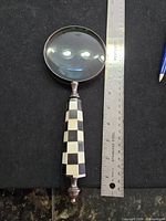 Full view of magnifying glass beside ruler showing 10" length