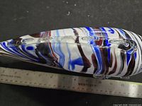 Profile of multicolour blown glass fish figurine with ruler for scale