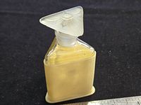 Full bottle with stopper in place showing overall form and ivory-tone sleeve