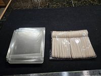 Stack of clear plastic boxes next to bundled wooden spoons
