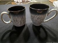 Front view of two Denby granite style mugs