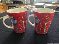Front view showing both Iittala Taika red mugs