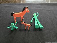 All four Gumby and Pokey figures grouped on black background