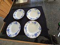 Four flow blue plates on black surface