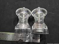 Front view of both clear acrylic grinders beside ruler showing 4" height