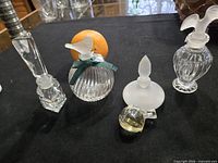 Group shot of five glass perfume bottles on black background