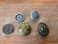 Front view of five military buttons