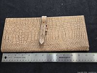 Front view of Birks crocodile calf document holder with ruler for scale