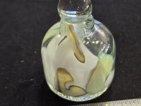 Perfume bottle front view showing swirl pattern and stopper