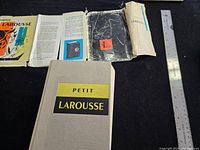 Front view of hardcover dictionary and removed dust jacket, ruler for scale