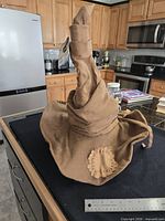 Full view of the brown fabric Sorting Hat on counter with ruler for scale