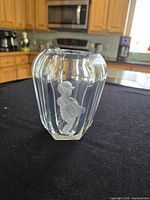 Front view of clear crystal vase showing vertical panels and frosted child engraving