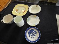 Overview of six ceramic items laid out on black cloth