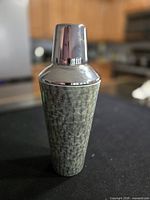 Full view of shaker showing stainless cap and faux shagreen body