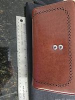 Closed wallet next to ruler showing length