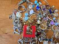 Pile of assorted jewellery pieces on wood surface showing variety of items
