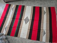 Full view of woven striped blanket laid flat