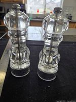 Front view of both clear acrylic grinders standing upright beside ruler showing 7 in. height