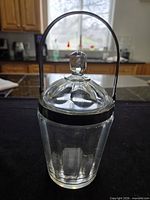 Full view of biscuit barrel with metal handle and glass lid