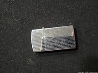Slim Zippo lighter front view showing brushed chrome with engraved lines