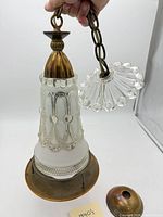 Full view of chandelier showing brass top, glass body, chain, and canopy