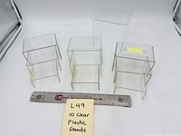 Top view of all ten clear acrylic stands with ruler for scale