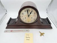 Front view of mantle clock with ruler and key for scale
