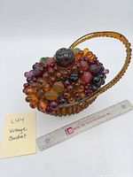 Full view of amber glass basket with fruit arrangement and ruler for scale