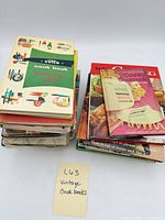 Two stacks of assorted vintage cookbooks, front covers visible