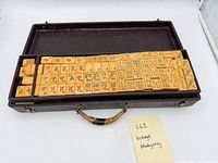 Closed view of open carrying case showing stacked trays of yellow Mahjong tiles