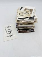 Stack of photographs next to handwritten note indicating 300 photos