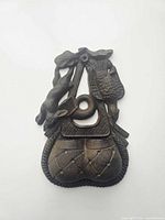 Front view of cast iron match safe showing rabbit and duck motifs and quilted pocket