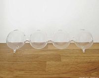 Overall view of clear glass bud vase showing four bubble compartments and feet