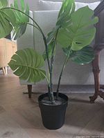 Full view of artificial monstera plant in black pot