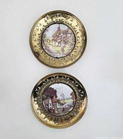 Front view of both brass wall plates showing foil art and reticulated rims