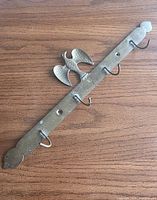 Full view of brass rack showing four hooks and eagle crest