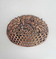 Front view of pierced copper-plated cast iron floral basket trivet