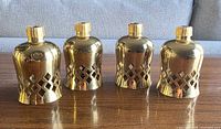 Front view of all four brass peglites displaying lattice pattern