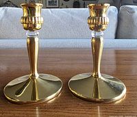 Both Partylite Richmond brass candle holders standing on table