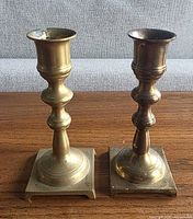 Both brass candlesticks front view showing shape and bases