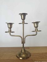 front view of brass three-arm candle holder
