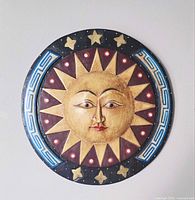 Front view showing carved and painted sun face, stars and border