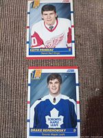Front view of both cards showing players, team names, rookie badge